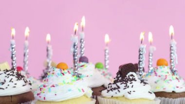 Doğum günü partisi için kremalı kek üzerine doğum günü mumları üflüyorum.