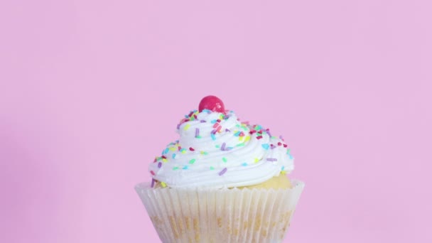 慢慢地旋转一个带有粉红色主题的奶油的杯子蛋糕 — 图库视频影像
