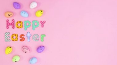 Mutlu Paskalya metinleri ve yumurtalar pembe temanın sol tarafında. Hareketi durdur