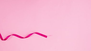 Pembe kurdele ve çiçekler pembe temada görünür. Hareketi durdur