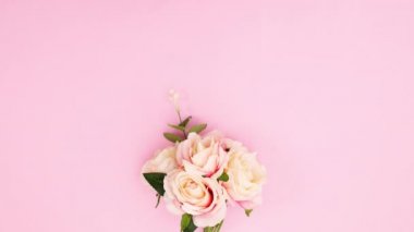 Pastel pembe temada gül, inci ve kurdelelerden oluşan romantik bir buket belirir. Hareketi durdur 