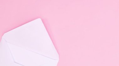 Zarftaki kağıt, pastel pembe temalı gül buketiyle birlikte görünür. Hareketi durdur