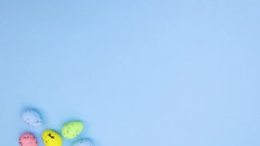 Paskalya yumurtaları pastel mavi temanın sol tarafında görünür ve metin için boşluk bırakır. Hareketi durdur