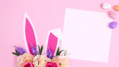 Tavşan kulaklı Paskalya yerleşimi, çiçek aranjmanı, yumurta ve kağıt kart. Dur hareketi düz yatıyordu