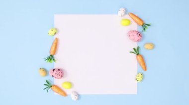 Havuçlu ve yumurtalı paskalya kartı notu pastel mavi arka planda hareket ediyor. Minimum stop hareketi düz yatıyordu