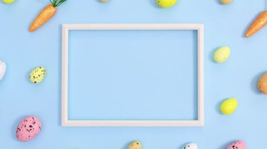 Yumurta ve havuçlu Paskalya deseni ve parlak pastel mavi arka planda uzay çerçevesini kopyalamak. Dur hareketi düz yatıyordu