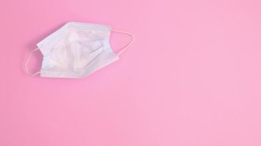 Yüz maskesi pastel pembe arka planda görünür ve canlı yumurtalar içinde görünür. Dur hareketi düz yatıyordu