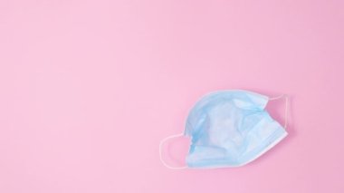 Paskalya yumurtaları pastel pembe arka planda yüz maskesi içinde görünür. Düz yatıyordu minimum durma hareketi