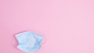 Pastel pembe arka planda tavşan kulaklı yaratıcı yüz maskesi görünür ve içinde yumurtalar belirir. Dur hareketi düz yatıyordu