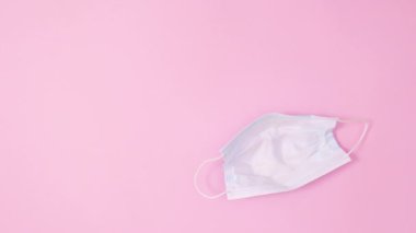 Pastel pembe arka planda Paskalya canlı yumurtaları olan yüz maskesi. Dur hareketi düz yatıyordu