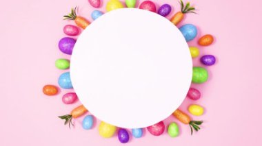 Kağıt kart notu, Pastel pembe arka planda canlı paskalya yumurtalarıyla çevrili. Hareketi durdur