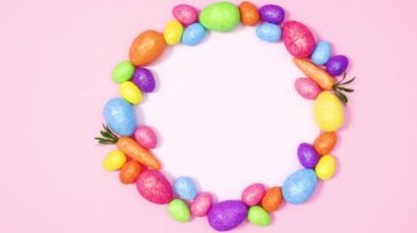 Kağıt kart notu, Pastel pembe arka planda canlı paskalya yumurtalarıyla çevrili. Hareketi durdur