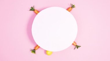 Paskalya yumurtaları pastel pembe arka planda kağıt kart etrafında belirir. Dur hareketi düz yatıyordu