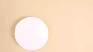 Kulakları olan yaratıcı Paskalya tavşanı çıplak arka planda yuvarlak kağıt notun altında belirir. Minimum düz duruş hareketi