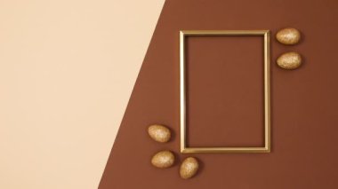 Paskalya için altın parıltılı yumurtalarla dolu altın fotokopi çerçevesi. Hareketi durdur 