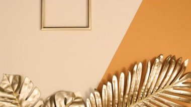 Altın tropik palmiye yaprakları ve altın fotokopi alanı çerçevesi çıplak arkaplanda görünür. Hareketi durdur