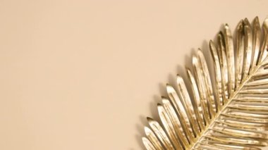 Çıplak arka planda altın palmiye yaprağını hareket ettirme fikri asgari düzeyde. Hareketi durdur