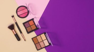 Göz farı paletleri ve fırçalar mor, pastel pembe ve bej arka planda hareket eder. Hareketi durdur