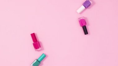 Parlak pembe arka planda tırnak cilası şişeleri ve dosyalardan oluşan yaratıcı bir kopya alanı çerçevesi. Hareketi durdur