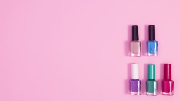 修指甲工具和指甲油瓶子出现在明亮的粉红色背景上 修剪工具的创造性布局 — 图库视频影像