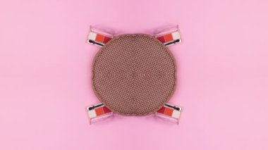 Makyaj setleri ve ürünler pastel pembe arka planda makyaj malzemelerinden çıkıyor. Dur hareketi düz yatıyordu