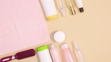 Bej arka planda pembe havluyla güzellik derisi spa ürünleri görünür. Hareketi durdur 