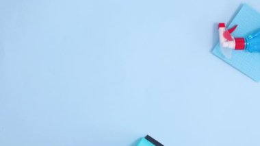 Ev temizlik araçları pastel mavi arka planda görünür. Hareketi durdur