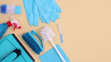 Fotokopi alanı olan bej arka planda temizlik araçlarının ve ev malzemelerinin düzenini kaydet. Hareketi durdur