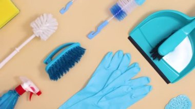 Yaratıcı ev temizlik aletleri bej arka planda hareket ediyor. Hareketi durdur