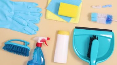 Ev temizleme araçlarından oluşan yaratıcı düzen bej arka planda hareket ediyor. Hareketi durdur