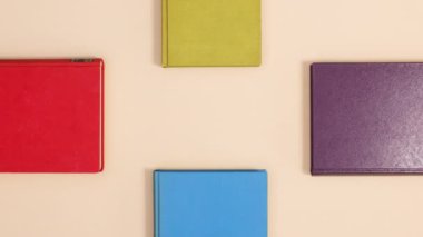 Bej arka planda dört köşeli dört ciltli klasik kitap var. Dur hareketi düz yatıyordu