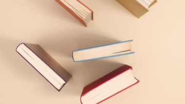 Bej arkaplan siparişi veren sert kapaklı eski kitaplar. Dur hareketi düz yatıyordu