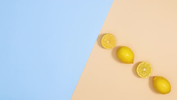 新鮮なレモンは青と砂の背景に表示されます 夏の柑橘類の停止運動フラットレイ — ストック動画