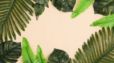 Yeşil tropik yapraklar egzotik çerçeve oluşturur ve bej arka planda kopya alanı ile hareket eder. Dur hareketi düz yatıyordu