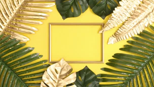 热带地区的金色和绿色叶子在夏季黄色背景的金色框架周围移动 并带有复制空间 停止运动平铺 — 图库视频影像