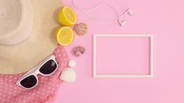 Kopya uzay çerçevesi, yaz modasına uygun plaj aksesuarlarının yanında, pastel pembe arka planda görünüyor. Dur hareketi düz yatıyordu