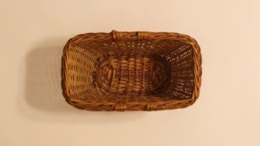 Wooden basket appear on beige background and citrus fruits appear in it. Stop motion flat lay 