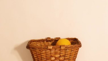 Wooden basket and fresh citrus fruits move on beige background. Stop motion flat lay