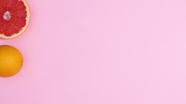 Taze narenciye meyveleri pastel pembe arka planda fotokopi alanı ile birlikte görünür. Dur hareketi düz yatıyordu