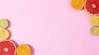 Beautiful fresh summer citrus fruits move frame on bright pink background. Stop motion