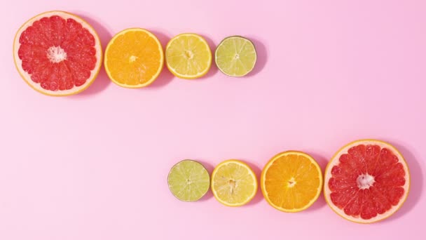 Skivade Färska Citrusfrukter Visas Två Sidor Pastellrosa Bakgrund Med Kopieringsutrymme — Stockvideo