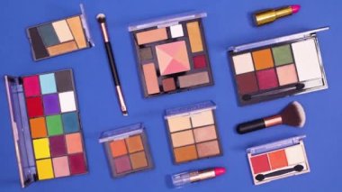 Koyu mavi arka planda makyajdan oluşan yaratıcı bir model. Dur hareketi düz yatıyordu