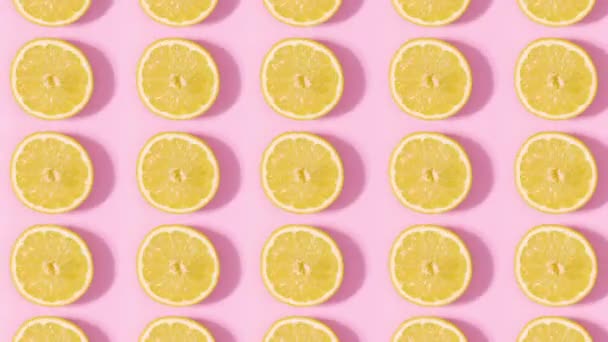 Padrão Feito Limões Cítricos Fatiados Girando Sobre Fundo Rosa Pastel — Vídeo de Stock
