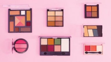 Göz farı paletlerinden yapılmış yaratıcı düzen pastel pembe arka planda hareket ediyor. Hareketi durdur