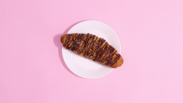 Finom Csokoládé Croissant Mozog Fehér Lemez Pasztell Rózsaszín Háttér Állj — Stock videók