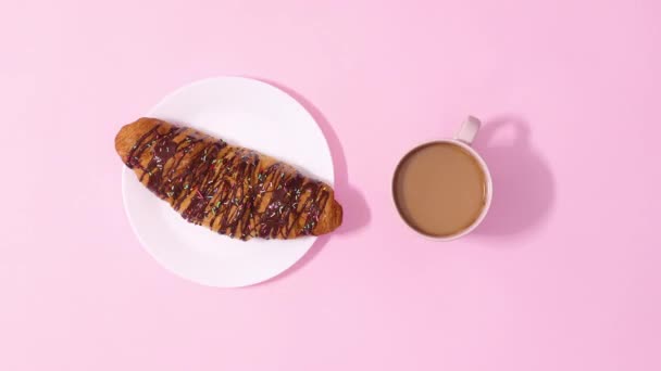Čerstvý Lahodný Čokoládový Croissant Rotující Šálkem Kávy Pastelově Růžovém Pozadí — Stock video