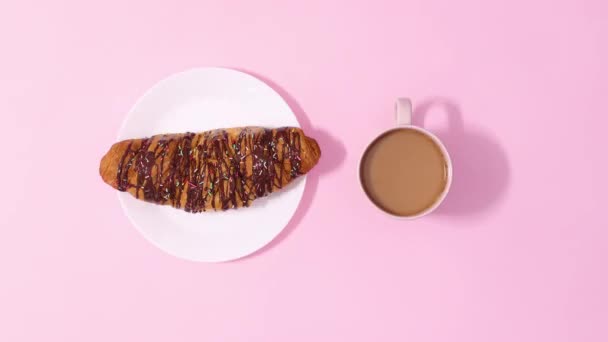 Färsk Läcker Choklad Croissant Roterande Med Kopp Kaffe Pastell Rosa — Stockvideo