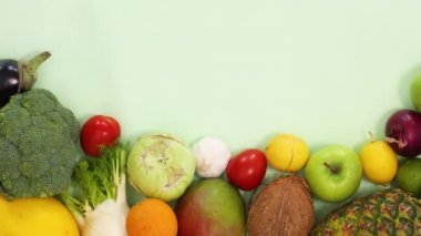 Açık yeşil arka planda sıralanmış taze organik meyve ve sebzeler. Sağlıklı yiyeceklerin olduğu düz hareket etmeyi kes.