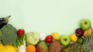 Taze organik meyve ve sebzeler açık yeşil arka planda sıralanır. Sağlıklı yiyeceklerin olduğu düz hareket etmeyi kes.