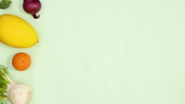 Sağlıklı taze meyve ve sebzeler açık yeşil arka planda desen oluşturur. Hareketi durdur